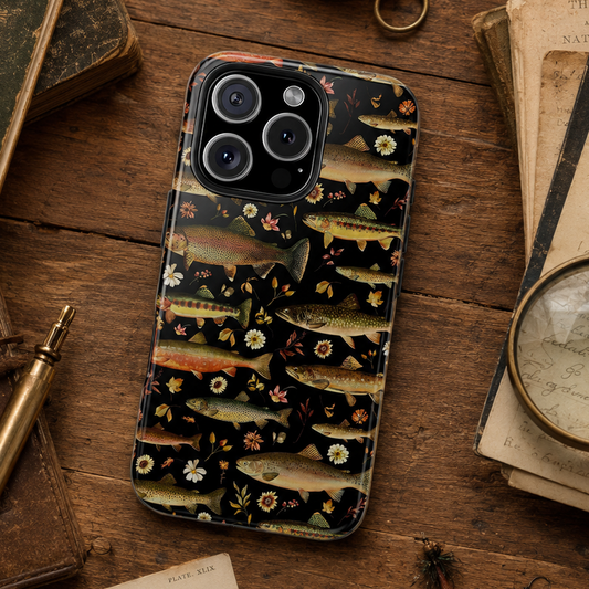 Phone case with trout design on a wooden surface with vintage books and tools