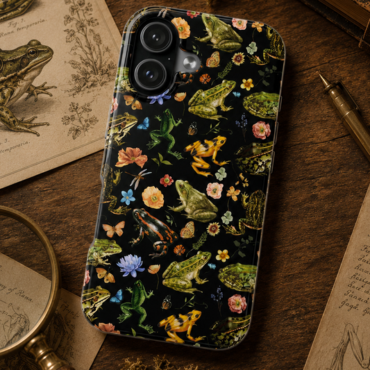 Phone case with nature-themed design featuring frogs and flowers on a wooden surface.