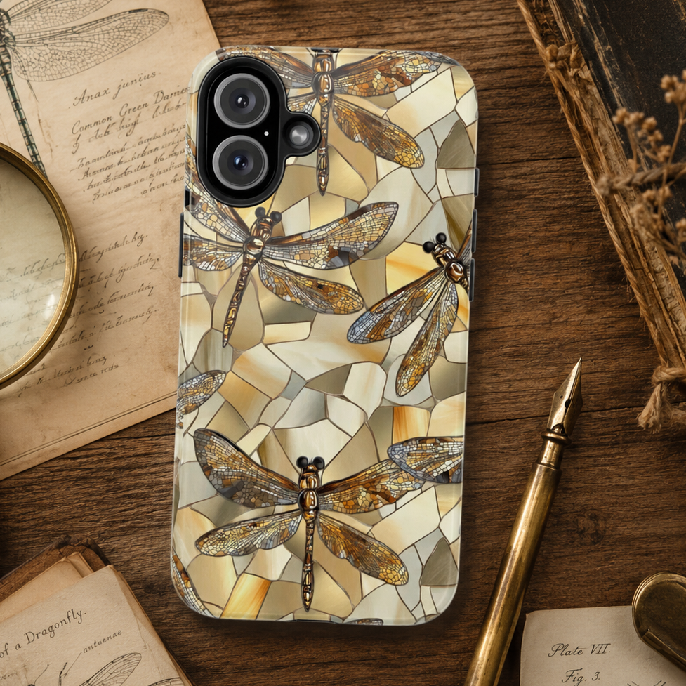 Phone case with dragonfly design on a wooden surface with books and a pen.