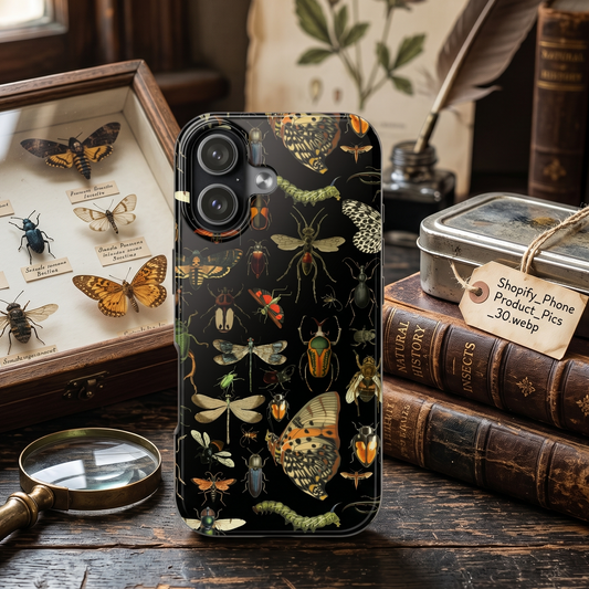 Phone case with insect design on a wooden table with books and a magnifying glass.