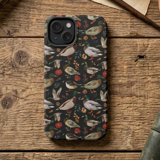 Phone case with mallard duck pattern on a wooden surface with books and a plant.
