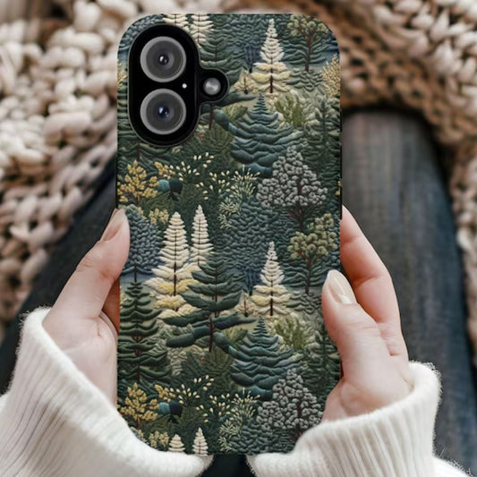 Phone case with forest design held by a person wearing a white sweater against a textured beige background