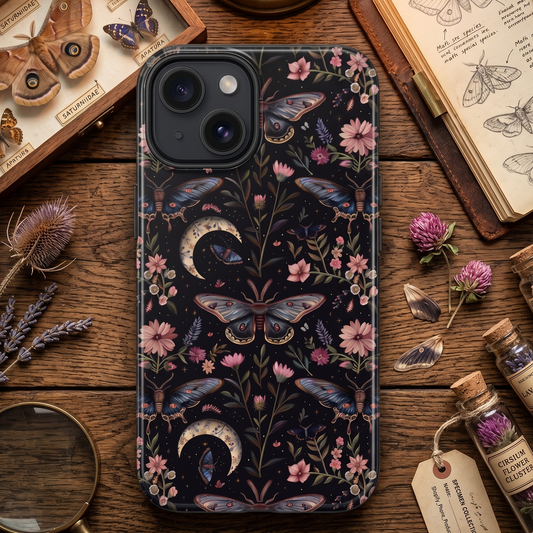 Phone case with butterfly and floral design on a wooden surface with books and bottles.