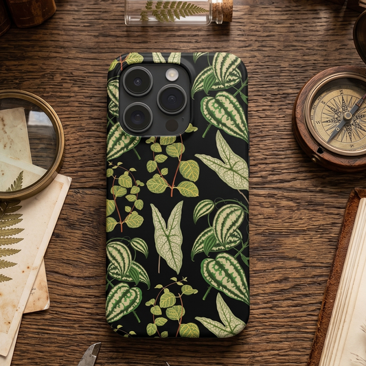 Phone case with leaf pattern on a wooden desk with vintage items