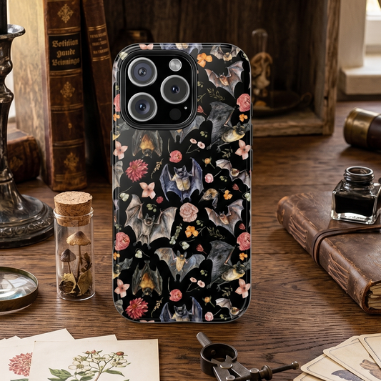Phone case with nature-themed design on a desk with books and stationery