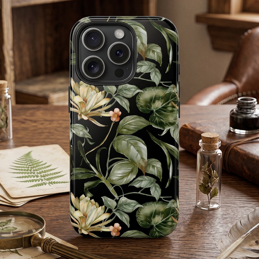 Phone case with floral design on a wooden table with books and bottles